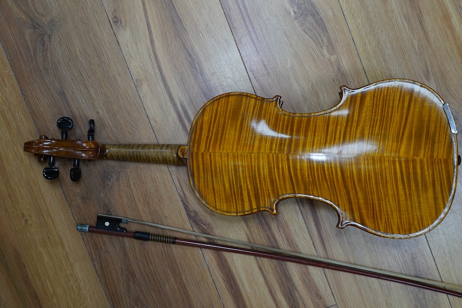 A cased early 20th century European violin, with label reading ‘Antonius Stradivarius Cremonenfis’, body length 36cm, with P&H London bow. Condition - good